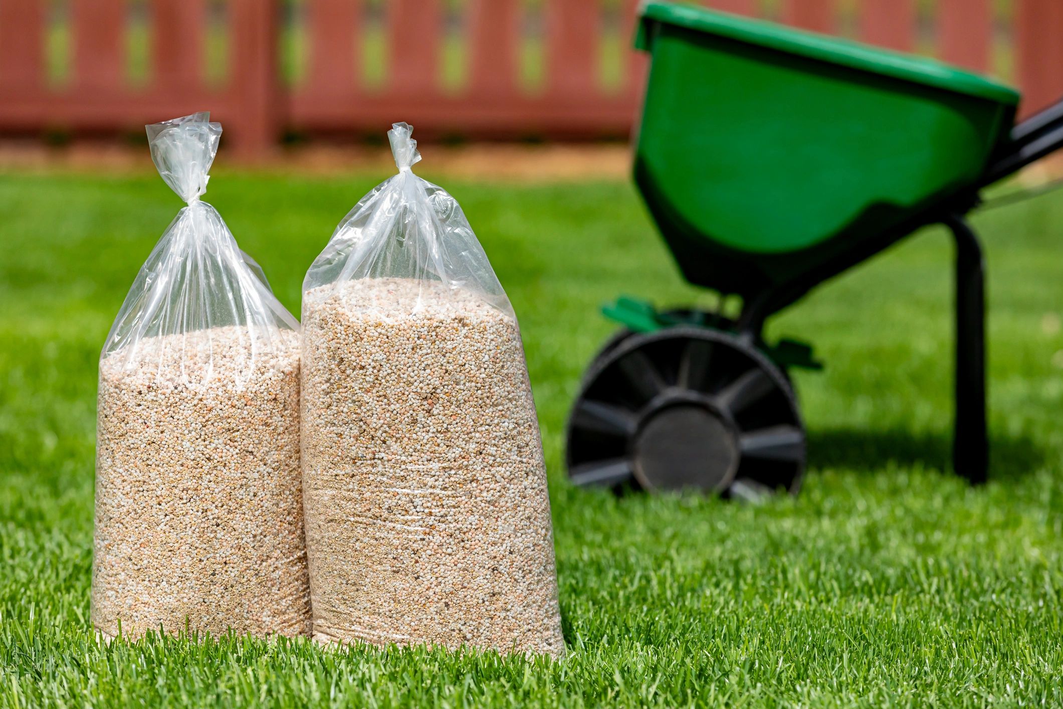 Bags of lawn fertilizer on grass