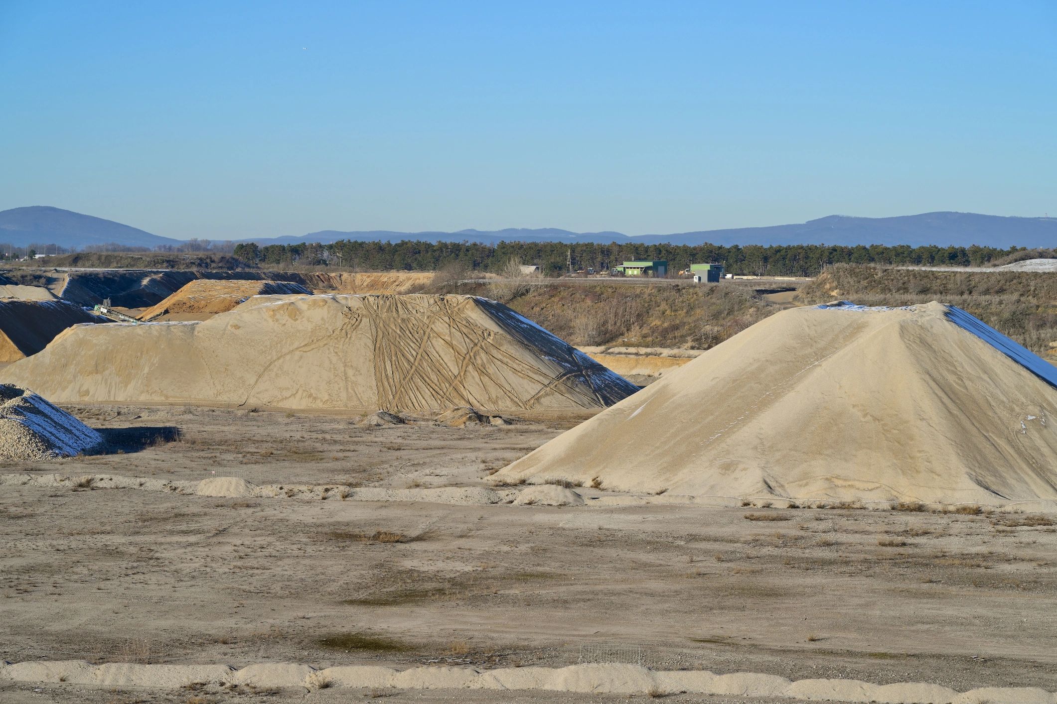 Landscape supply yard with large gravel and aggregate stockpiles