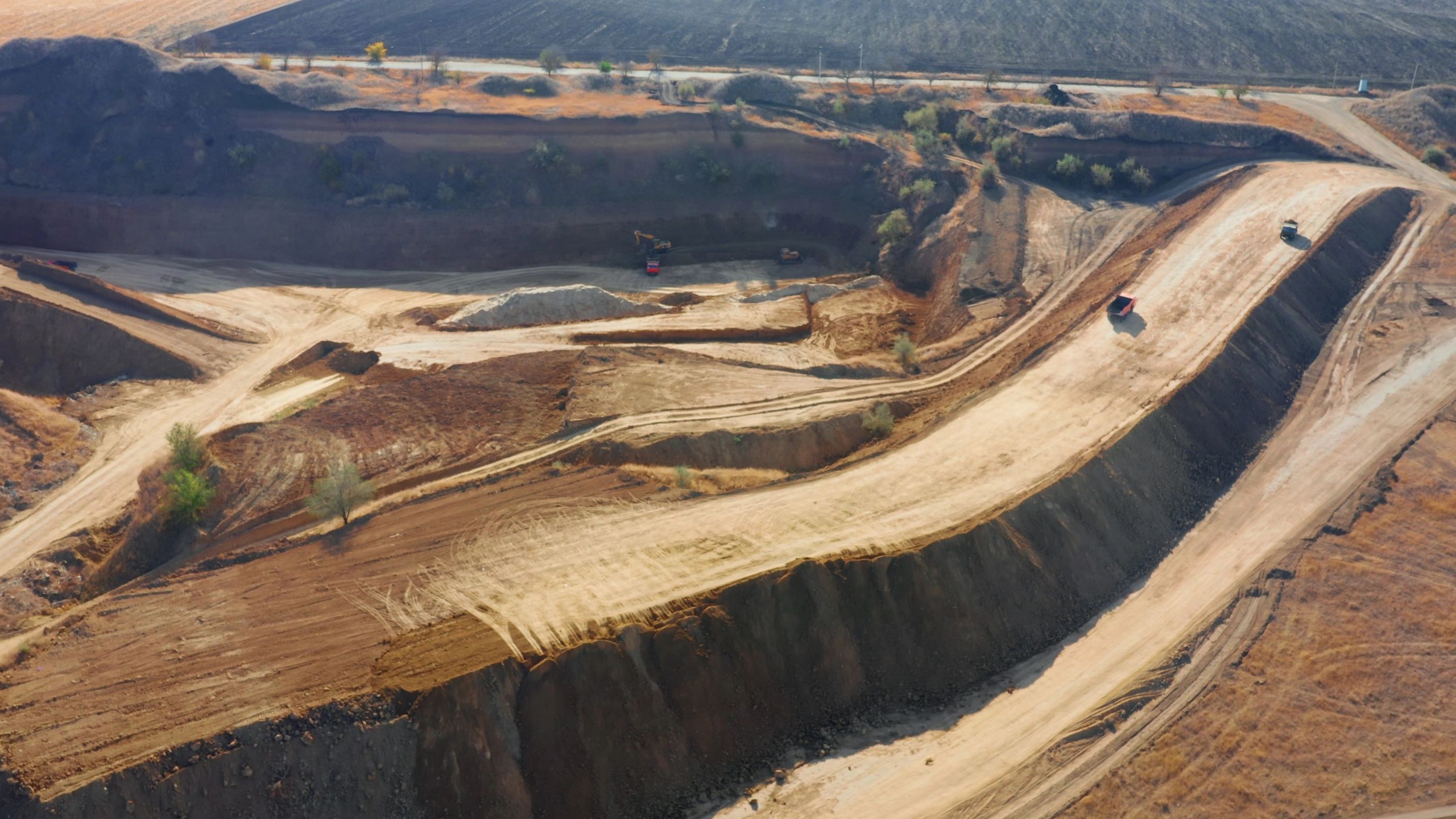 Haul trucks moving materials along quarry roads